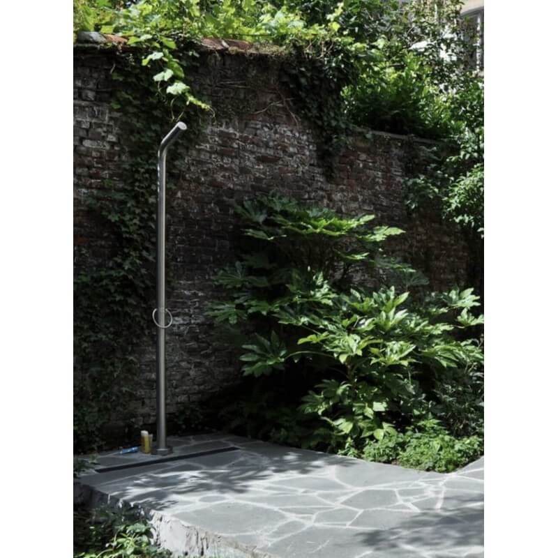Zahradní sprcha JEE-O pure 01 na kamenné podlaze u kamenné zdi obrostlé zelení