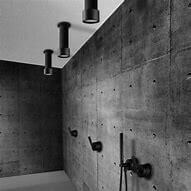 3 stropní sprchy JEE-O soho umístěné v interiéru, baterie a ruční sprcha umístěné na zdi