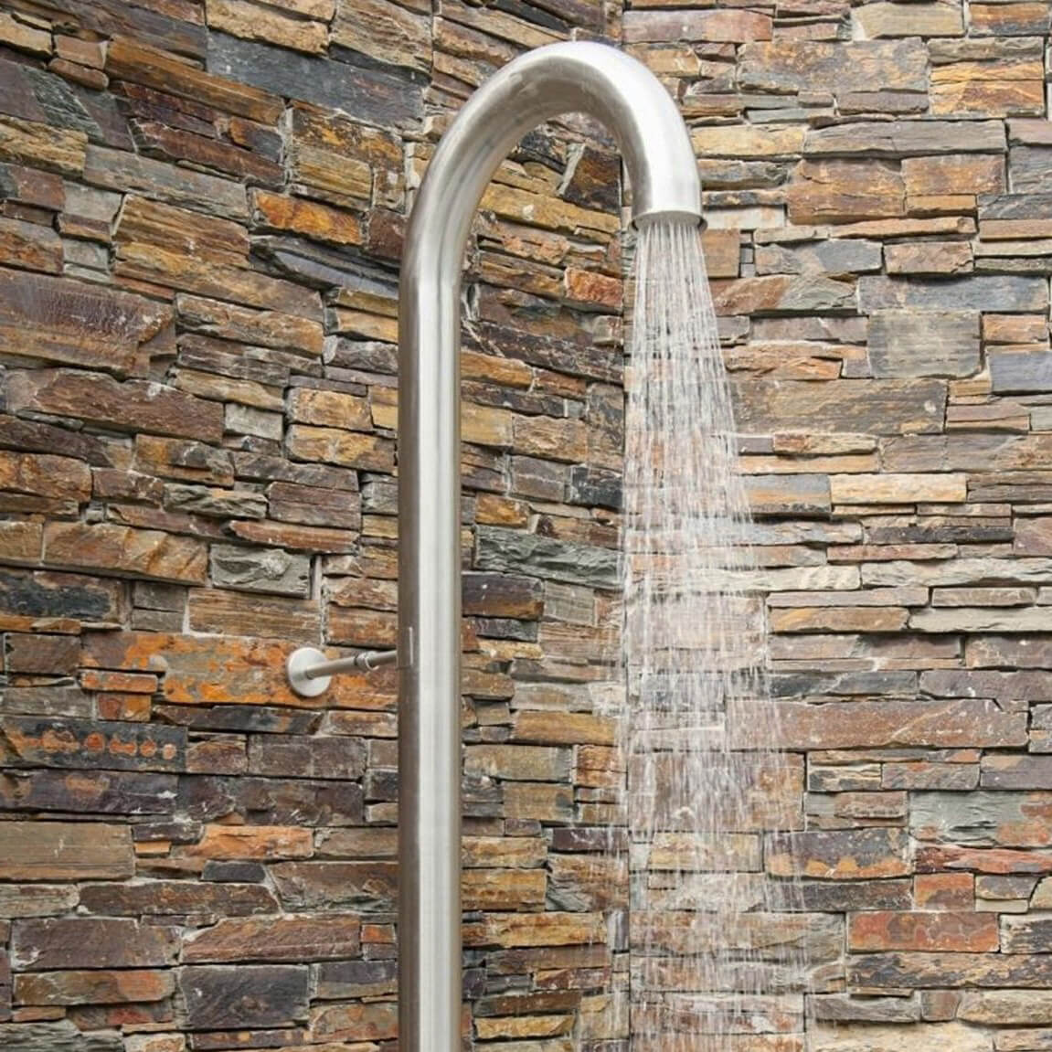 Nerezová venkovní sprcha JEE-O original připevněná úchytem ke kamenné zdi