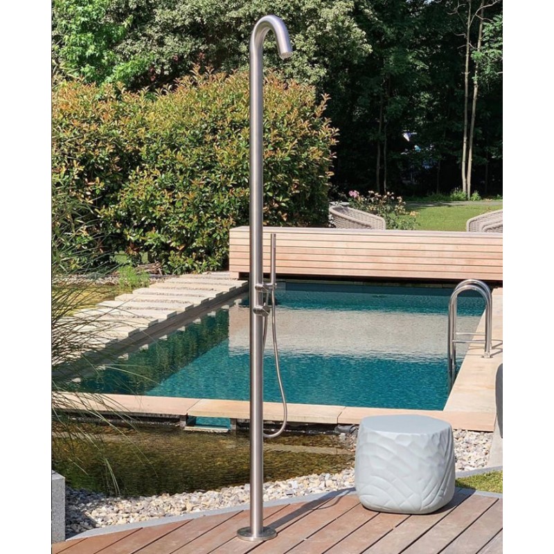 Sprcha Fuoco z broušené nerezové oceli s ruční sprchou umístěná na dřevěné terase u venkovního bazénu u rodinného domu